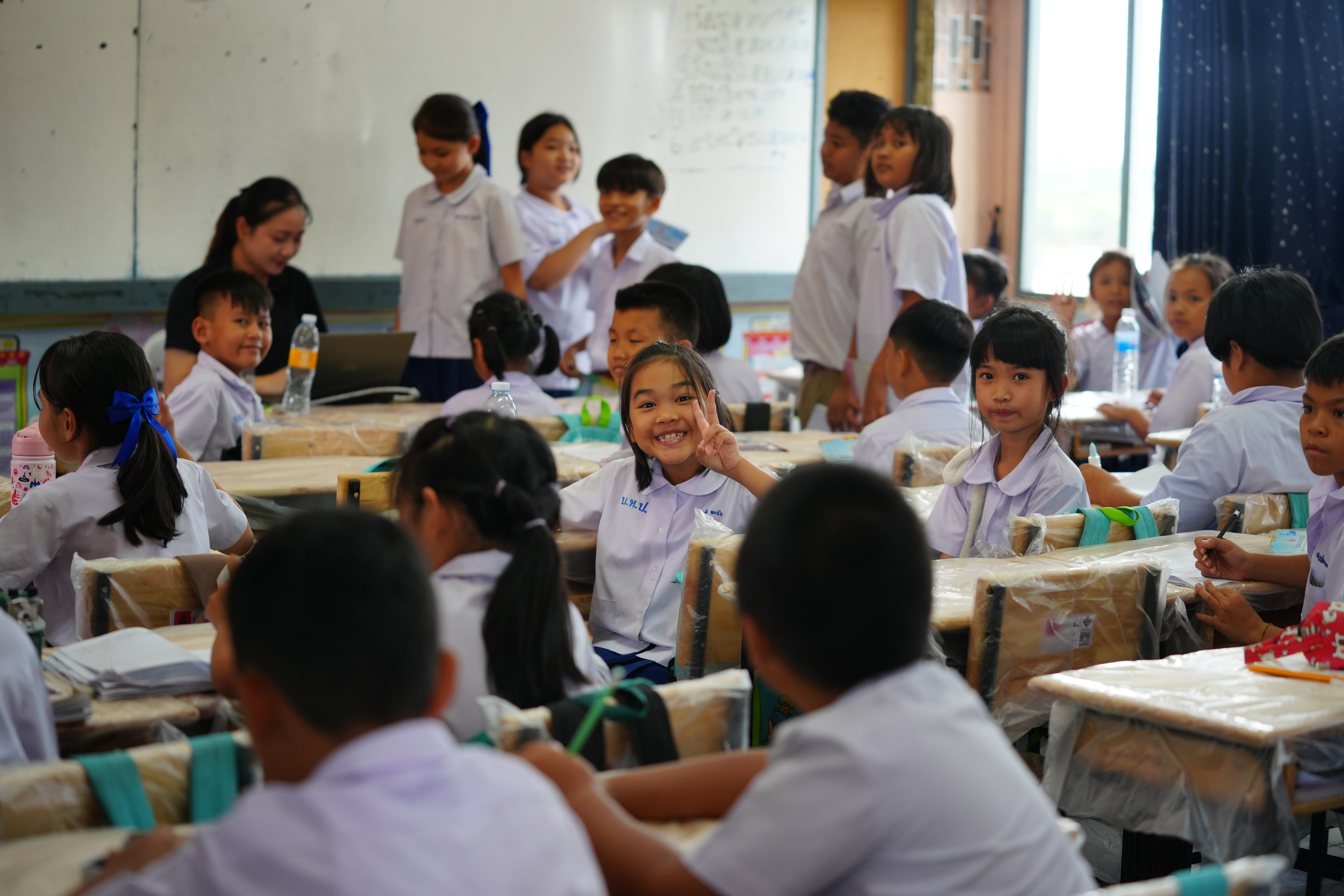 Students are excited to use their new desks for the first time at a school in Bangkok, Thailand, as part of Ford's Global Caring Month, September 2026.